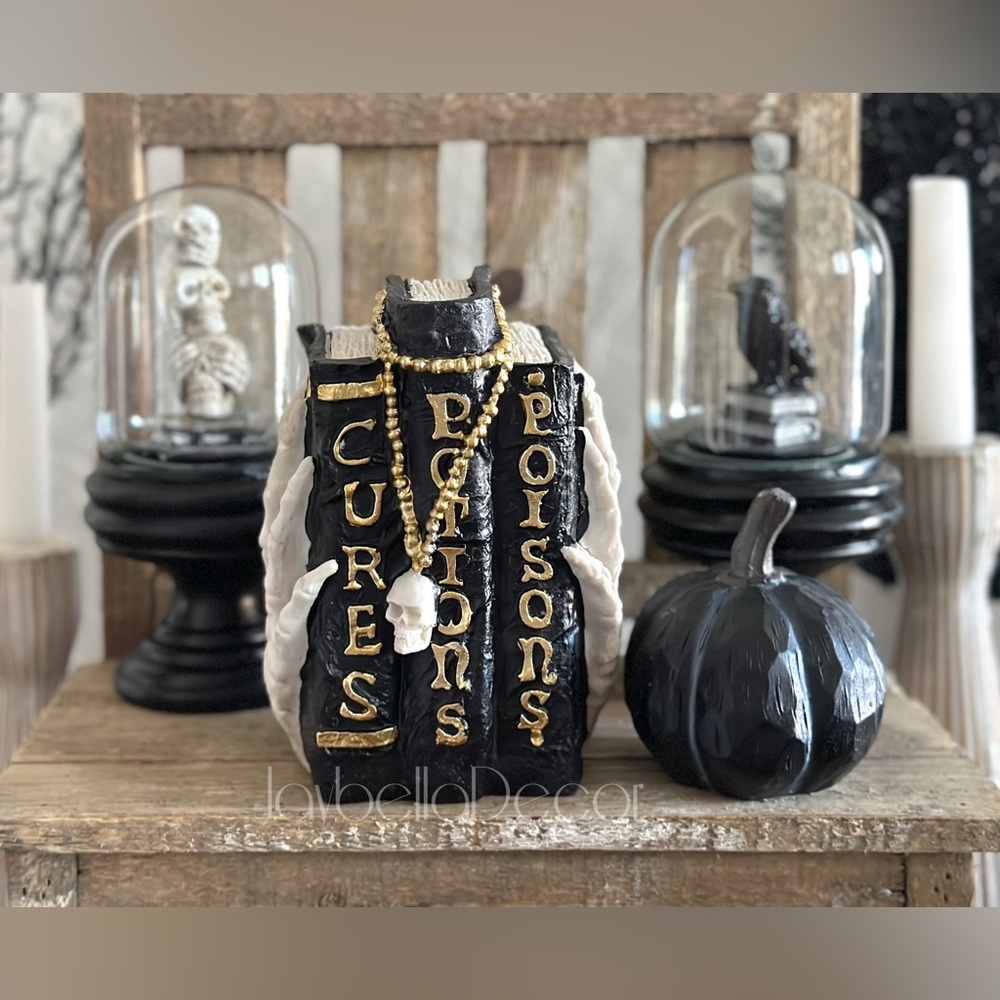 Hocus Pocus Spell Books Stack Statue being held by a Skeleton Hand for Halloween
